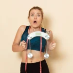 Mulher com rosto surpreso e segurando uma balança depois de medir metabolismo basal para emagrecer